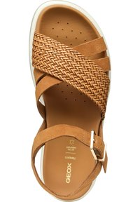 Tan suede sandaal met geweven banden, witte rubberen zool, verstelbare gesp en geperforeerde inlegzool voor ademend vermogen. Geox branding zichtbaar.