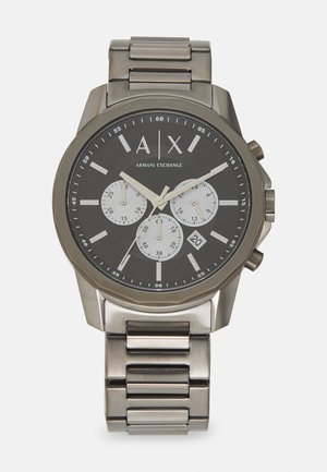 Męski zegarek analogowy ze stalową bransoletą, czarną tarczą, trzema sub-tarczami, srebrnymi znacznikami godzinowymi i wyświetlaczem daty na godzinie 6.