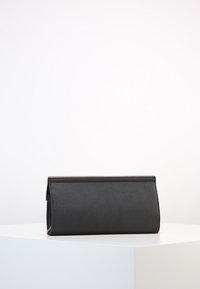 Portafoglio a busta nero con finitura testurizzata, forma rettangolare e un sottile accento della cerniera dorata. Linee pulite e design minimalista.