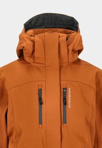 Orange Jacke mit hohem Kragen, grauem Innenfutter, zwei vertikalen Reißverschlusstaschen und einem Logo auf der Vorderseite. Wasserdichtes Material.