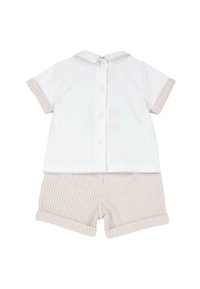 Ensemble bébé avec un haut blanc à manches courtes, boutons au dos et col, assorti à un short beige et blanc à rayures avec revers.