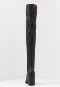 Zwart leren laarzen tot aan de knie met een gladde textuur, verticale naaddetail en een blokhak. Geschikt voor verschillende outfits.