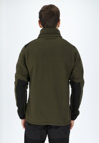 Pullover in felpa verde oliva con colletto alto, superficie testurizzata e pannelli neri a contrasto sulle maniche. Design semplice e funzionale.