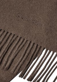 Sciarpa in cashmere marrone con bordo frangiato e logo "Calvin Klein" ricamato, che presenta una texture morbida e un design semplice.