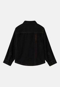 Chaqueta de mezclilla negra con mangas largas, cuello puntiagudo y detalles de costura en contraste. Cuenta con puños abotonados y un corte recto y estructurado.