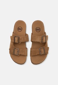 Sandalias de ante marrón con dos correas ajustables y hebillas de metal, que cuentan con una suela plana y una plantilla suave.
