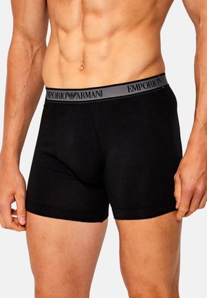 Schwarze Baumwoll-Boxershorts mit einem grauen, markenprägenden elastischen Bund mit der Aufschrift "EMPORIO ARMANI". Glatte Textur und körperbetontes Design.