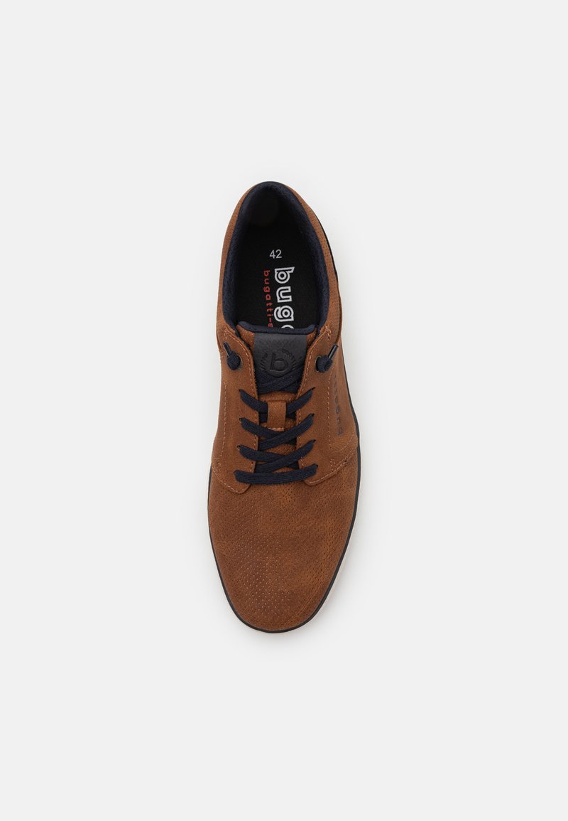 Chaussure en suede marron avec lacets noirs, texture perforée, bout rond et détail de logo. Taille 42 imprimée à l'intérieur de la chaussure.