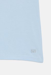 T-shirt azzurro chiaro a maniche corte realizzato in tessuto morbido, con un sottile logo "ULTRA DRY" grigio in basso a destra.