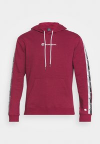 Sweat à capuche bordeaux avec cordons blancs, poche avant et bandes latérales noires ornées de marquages blancs. Tissu doux, poignets et ourlet côtelés.