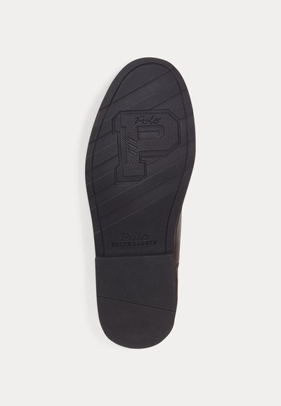 Suola di una scarpa nera con strisce testurizzate, una grande lettera P in rilievo e marchio "Polo Ralph Lauren" vicino al tallone.