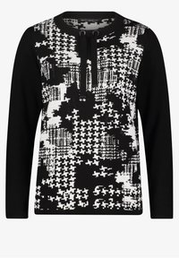 Svart och vit mönstrad långärmad topp med rund halsringning, utrustad med svart dragskoaccent och texturerade tygdetaljer.