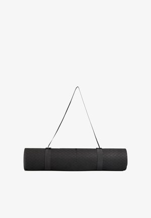 Černá jógová podložka stočená do role s texturovaným povrchem a popruhem pro přenášení. Má vzor rybí kosti a pevnou konstrukci.