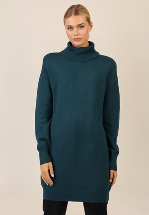 Teal turtleneck sweater lavet af blødt stof. Har lange ærmer, ribbet kant og en oversized pasform.