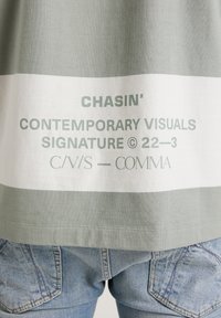 Grünes und weißes Grafik-T-Shirt mit dem Text "CHASIN' CONTEMPORARY VISUALS", aus weicher Baumwolle mit lockerer Passform und subtilen Nahtdetails.