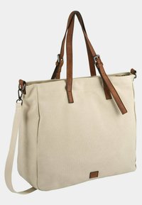 Sac en toile de jute dans un beige neutre, avec des poignées et des accents en cuir marron. Inclut une bandoulière ajustable et une forme carrée.