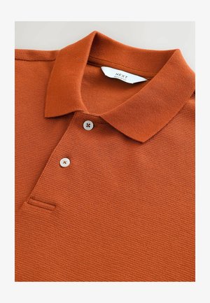 Rostfarbendes Polohemd aus strukturiertem Stoff, mit Kragen, einem Dreiknopfleiste und einer kleinen Brusttasche.