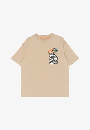 T-shirt en coton beige à manches courtes. Présente le texte "ROAD TRIP" ainsi qu'un graphisme représentant un cactus et un soleil sur le devant. Design simple et décontracté.