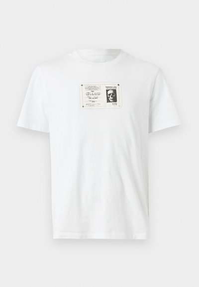 Tricou alb din bumbac, cu un imprimeu grafic alb-negru reprezentând un craniu într-un chenar dreptunghiular pe față. Mâneci scurte, guler rotund.