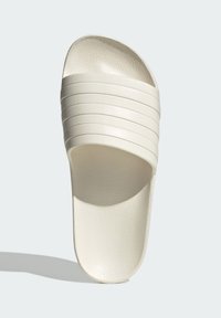 White slide sandal with four textured, horizontal stripes across the top and a smooth, rounded footbed. Made of synthetic material.
