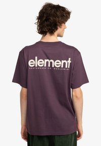 Camiseta de algodón morada con un gran logo blanco de "element" y texto en la parte posterior, con mangas cortas y un corte relajado.