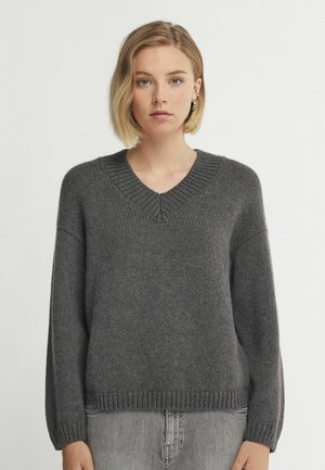 Grauer gestrickter Pullover mit V-Ausschnitt, überschnittenen Schultern und gerippten Bündchen. Die Textur ist weich, und das Design ist lässig und oversized.