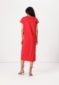Rotes Midi-Kleid mit kurzen Ärmeln, lockerer Passform und glattem Stoff. Verfügt über ein einfaches, nahtloses Design und endet knapp unter dem Knie.