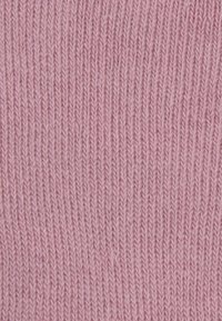 Hellrosa gestrickter Stoff mit einer glatten, gerippten Textur. Die Webart zeigt eine enge, gleichmäßige Nahtführung. Keine auffälligen Muster oder Akzente.