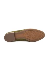 Green suede shoe with a textured brown rubber sole. The sole features a curved pattern and a slight heel, providing stability and comfort.