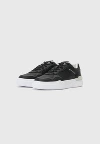 Sorte sneakers med en glatt lærøvre, hvit såle og grå detaljer. Inkluderer runde lisser og rund tådesign.
