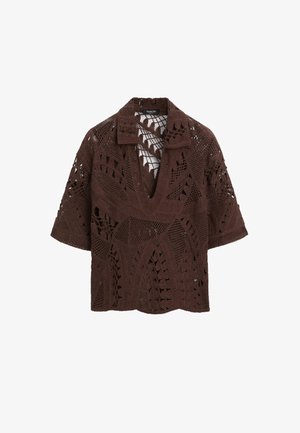 Haut marron crocheté à manches courtes avec col en V et motifs ajourés complexes sur tout le tissu.