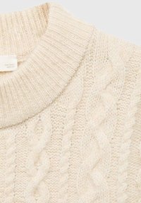 Pull en maille torsadée de couleur crème avec un col rond côtelé et un tissu en laine doux et texturé.