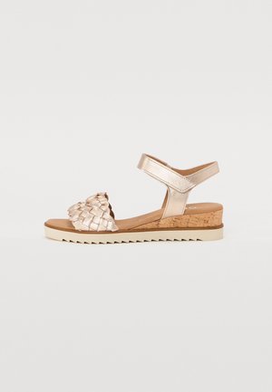 Geweven metallic gouden sandalen met een kurken wiggenhak, enkelbandje en een gestructureerde bovenkant, met een solide lichte zool en zigzagpatroon.