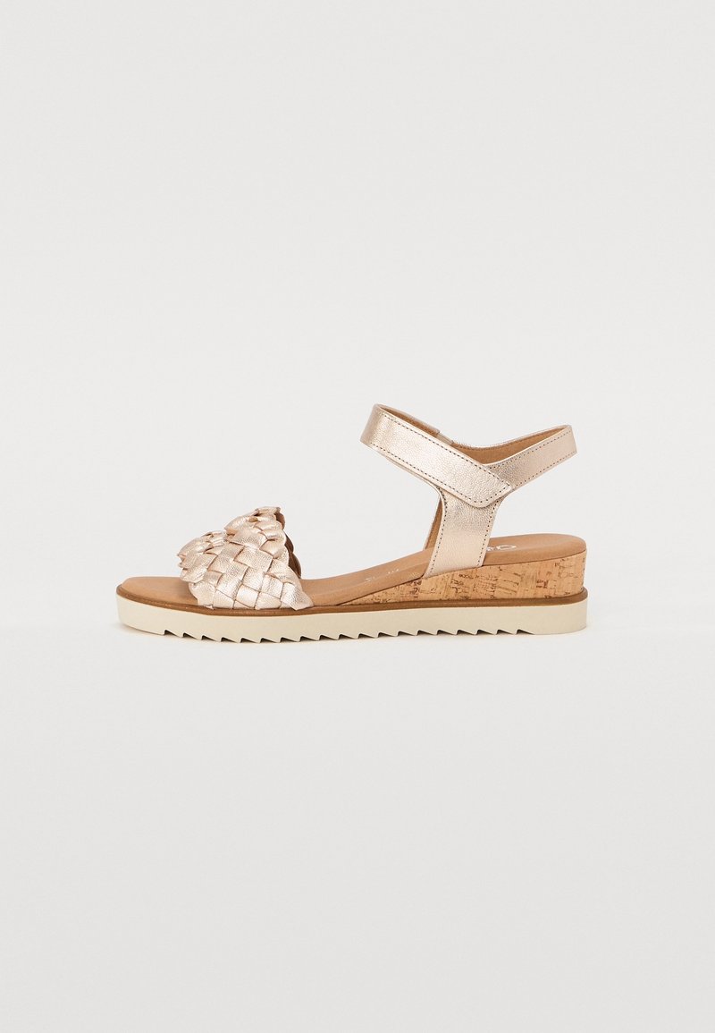 Aset metalliset kultasaappaat, joissa on korkkikorko, nilkkaremmi ja teksturoitu päällinen, jonka ominaisuuksiin kuuluu kiinteä vaalea pohja ja sahalaitakuviot.