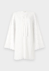 Tunic alb din dantelă, cu guler rotund, mâneci lungi și evazate, și un detaliu de legare în față. Fundația cu margini ondulate adaugă textură și interes vizual.