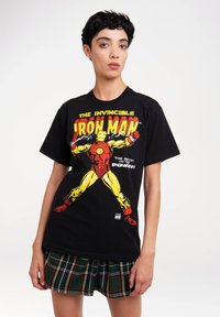 Schwarzes Baumwoll-T-Shirt mit einem bunten Grafikdesign von Iron Man, mit gelben und roten Akzenten und dem Text "DER UNBEZWINGBARE IRON MAN."