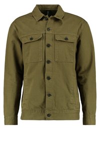 Veste en denim vert olive avec un devant à boutons, deux poches poitrine et des poches latérales. Dotée d'un col et de manches longues.