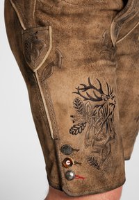 Pantalones cortos de cuero en color marrón con diseños en relieve de un ciervo y follaje. Incluye botones decorativos y detalles de costura.