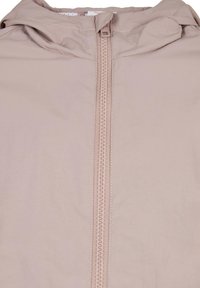 Lys rosa zip-up jakke med en glatt tekstur, med en sentral glidelås og hette, designet med subtile sømdetaljer.