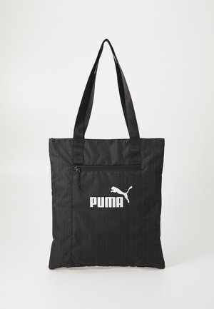 Black fabric tote bag with two sturdy straps, a front zip pocket, and white Puma logo. Features a textured pattern for added detail.