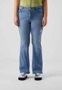 Light blue flared jeans with distressed detailing on the knees, featuring a five-pocket design and silver button closure.