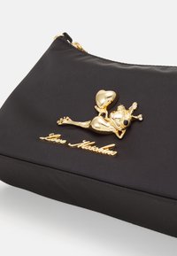 Borsa a pochette nera in nylon con un ciondolo a forma di rana dorata che tiene un cuore e il nome del marchio "Love Moschino" in scrittura dorata.