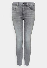 Jeans skinny de mezclilla gris con un acabado desgastado. Presenta cinco bolsillos, un cierre de botón y cremallera, y una textura suave.