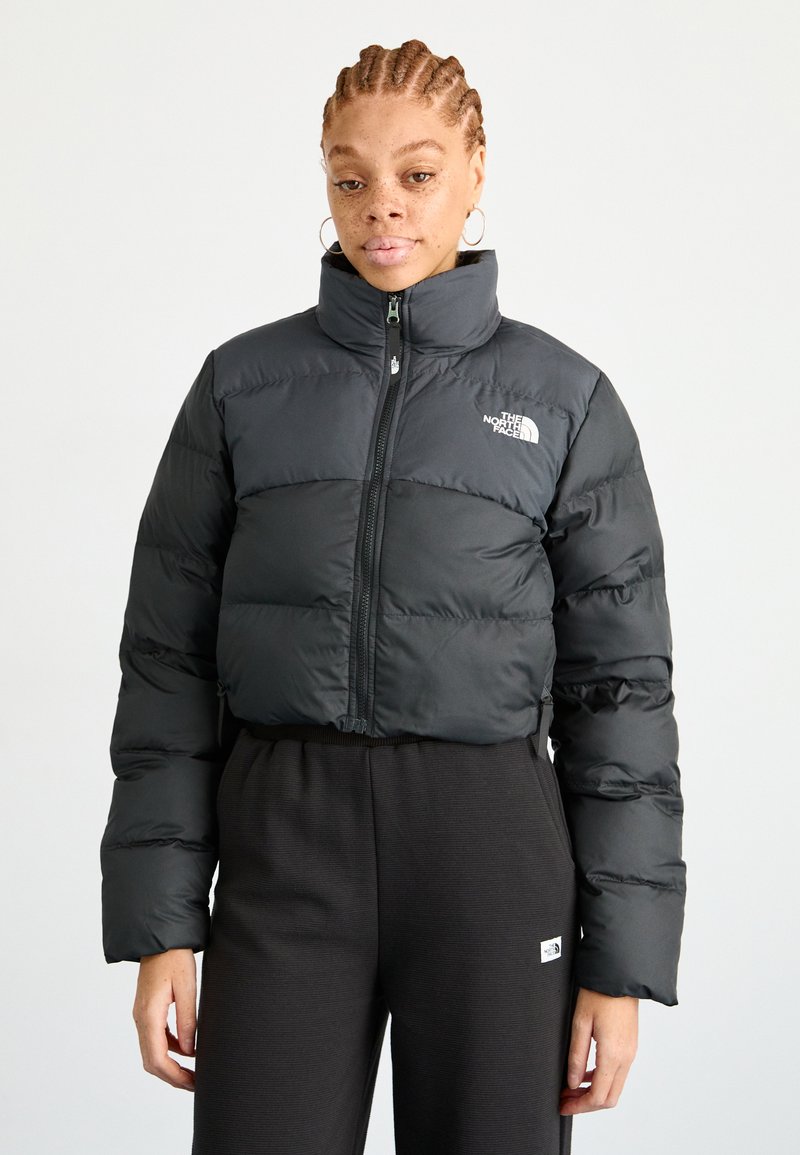 Černá zkrácená péřová bunda s vysokým límcem, s předním zipem a logem North Face na levé části hrudi. Hladká, lesklá textura.
