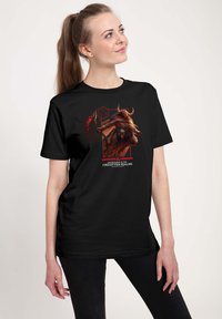 Czarny bawełniany t-shirt z kolorową grafiką postaci, z napisem "Dungeons & Dragons" oraz symbolem kostki D20 w czerwonych akcentach.
