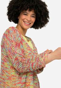 Multikleurige gebreide cardigan met een losse pasvorm, levendige rode, gele en blauwe patronen, met een V-hals en lange mouwen.