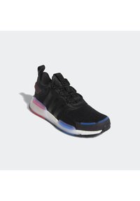 Black sneaker with mesh upper, featuring three textured stripes, elastic laces, and a multicolored sole with red, blue, and white accents.