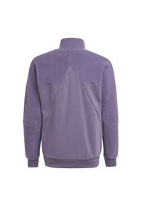 Lila tröja med hög krage, som kombinerar slät tyg och texturerad fleece på axlarna och ärmarna. Har diagonala sömmar.