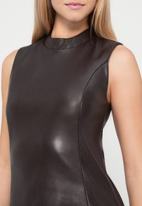 Bruine leren mouwloze jurk met een hoge halslijn, een gladde textuur en een op maat gemaakte pasvorm, met subtiele naaddetails.