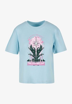 Lyseblå bomulds t-shirt med grafisk design med sorte hænder, en pink stjernespand og teksten "SHINE BRIGHT" ovenfor. Korte ærmer og rund hals.